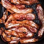 Golden crispy bacon in the air fryer basket after being cooked from frozen.