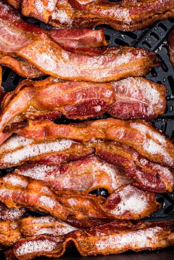 Golden crispy bacon in the air fryer basket after being cooked from frozen.