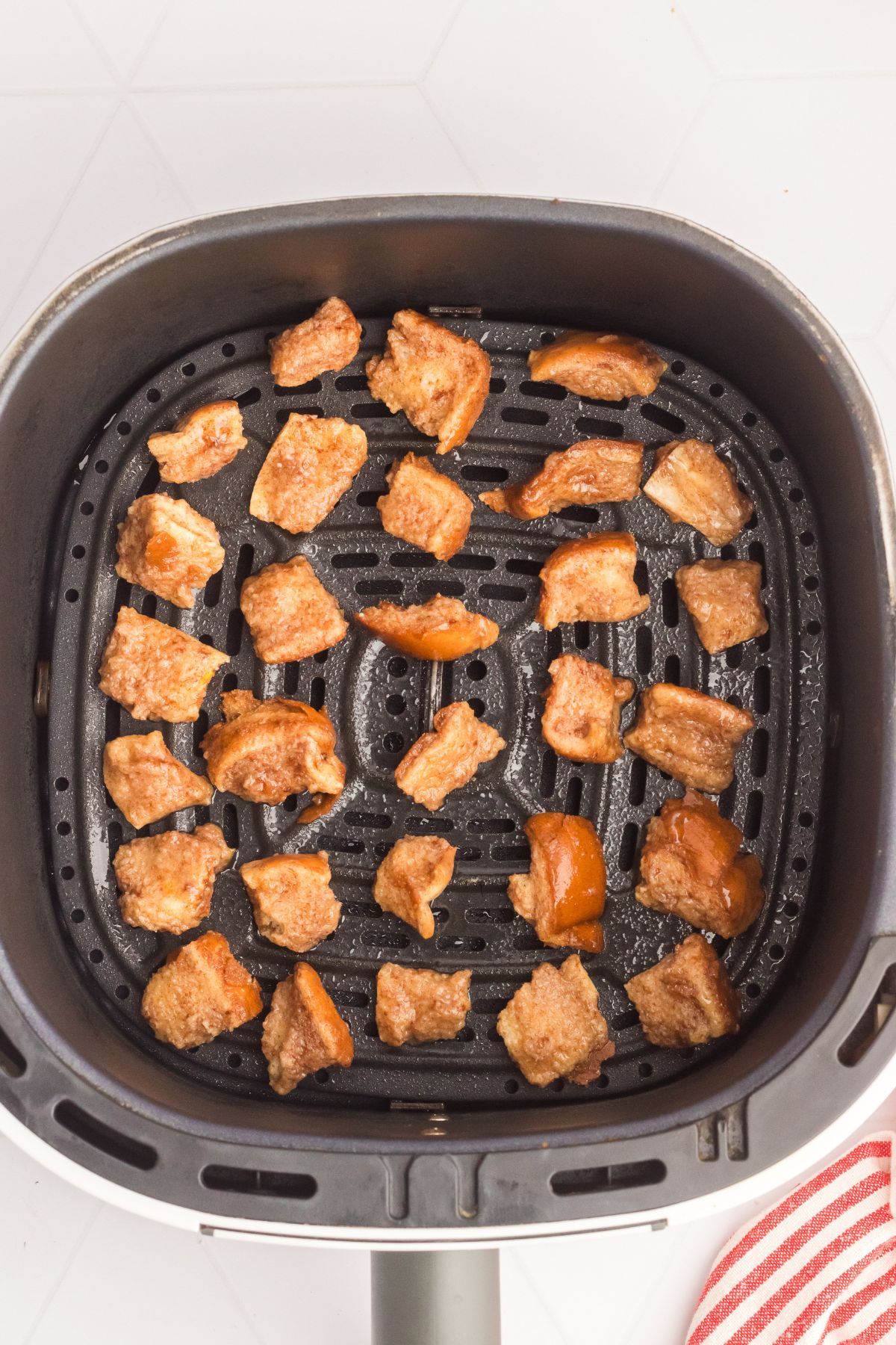 French toast bites in the air fryer basket before cooking. 