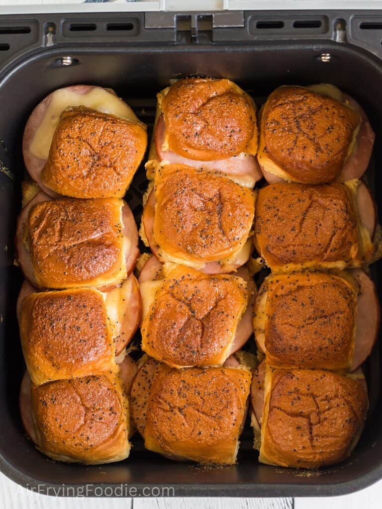 Ham and cheese sliders in the air fryer basket, ready to serve. 