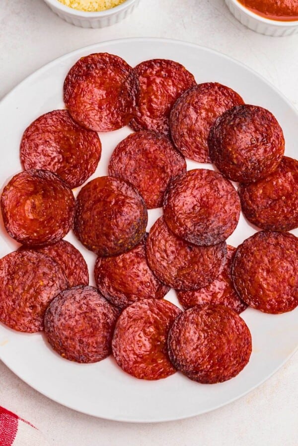 Crispy pepperoni chips on a plate after being air fried.