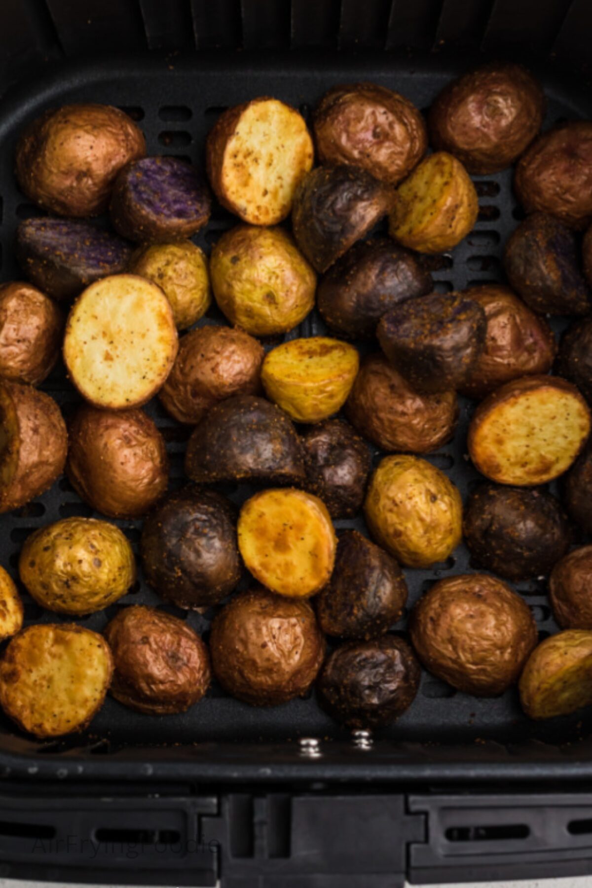 Crispy roasted potatoes in air fryer basket. 