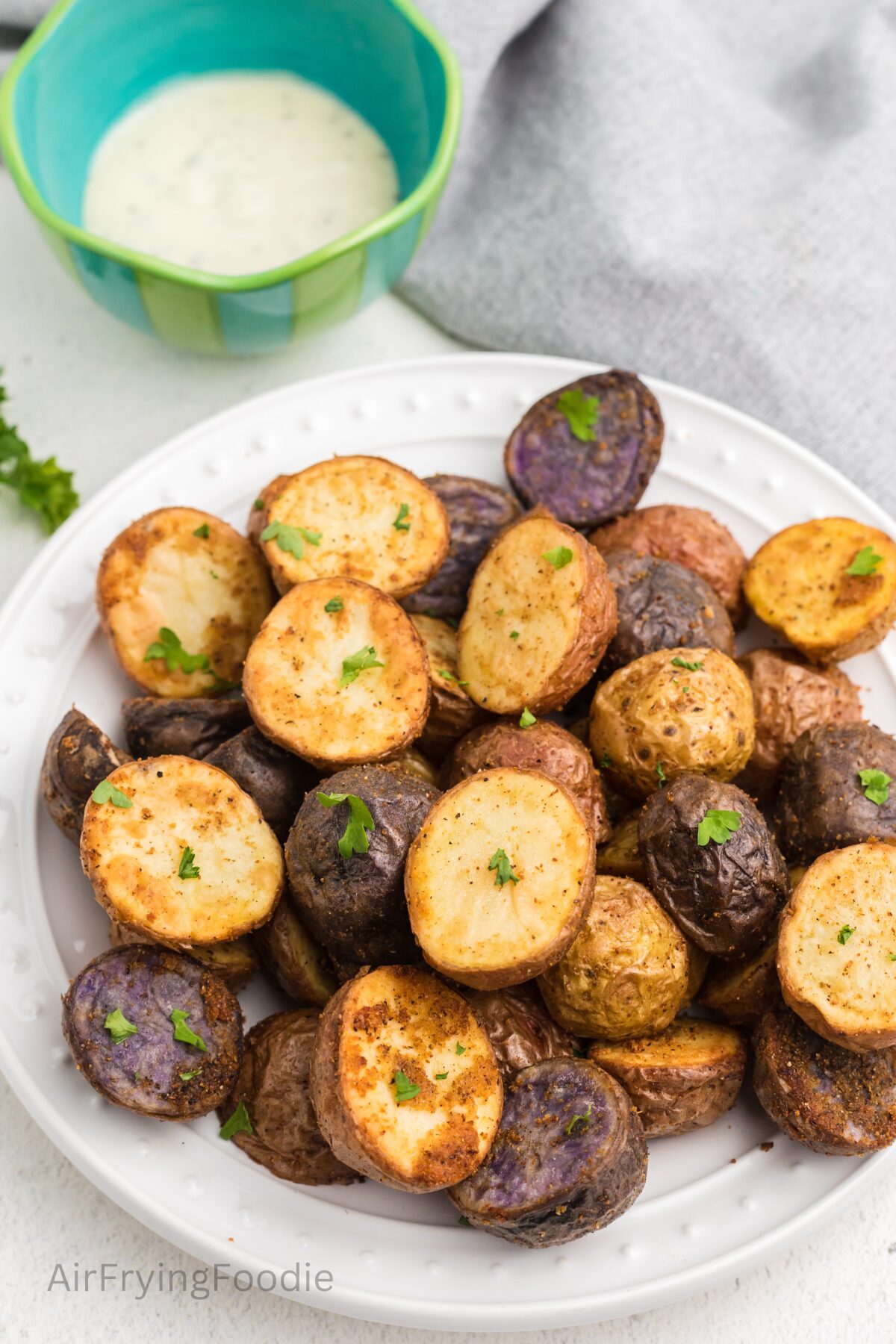 Roasted potatoes made in the air fryer, topped with chopped fresh parsley, and plated and ready to serve. 