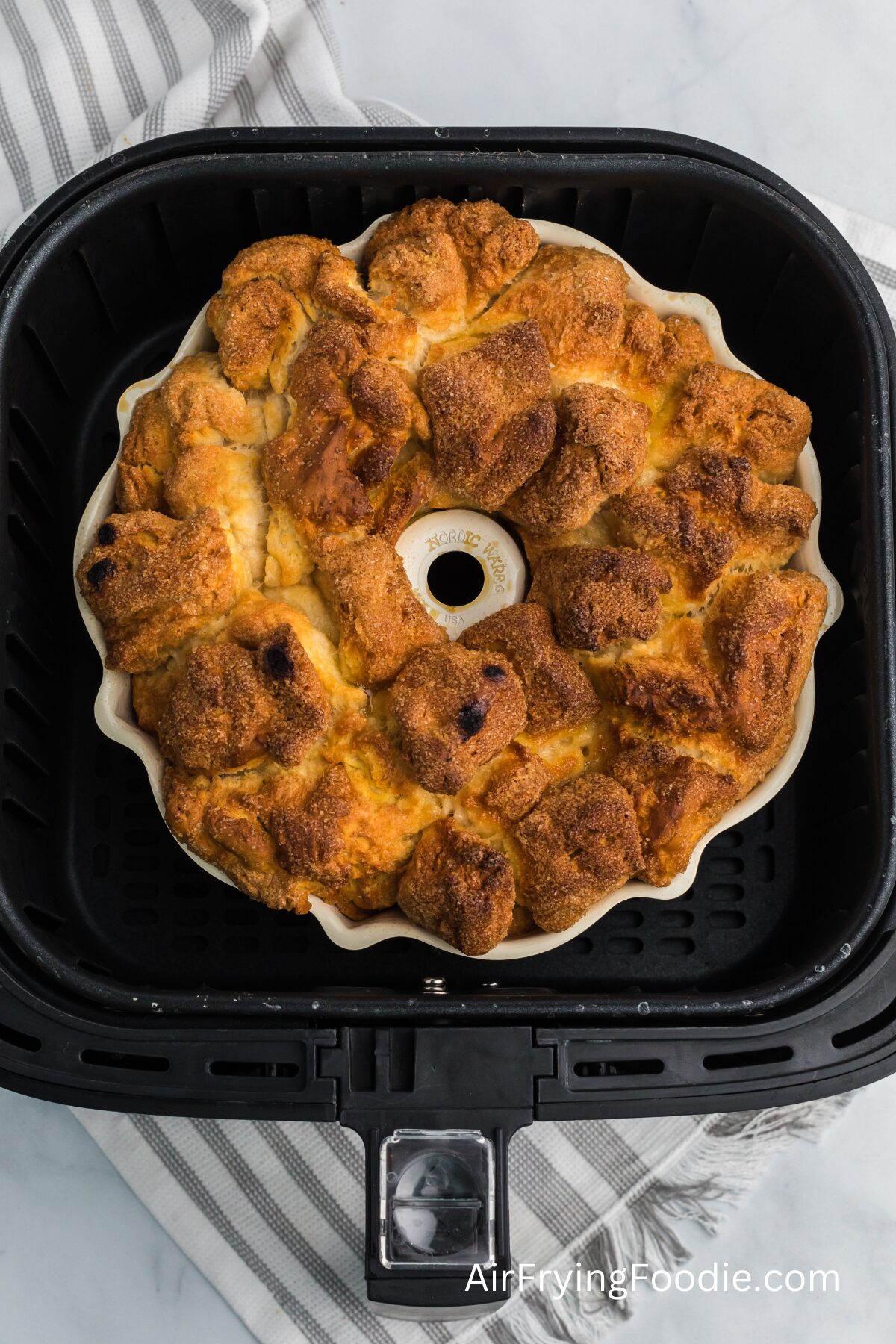 monkey bread fully cooked and in the air fryer basket, ready to be removed. 