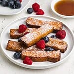 Air fried frozen french toast sticks fully cooked and topped with berries and powdered sugar. Ready to eat.