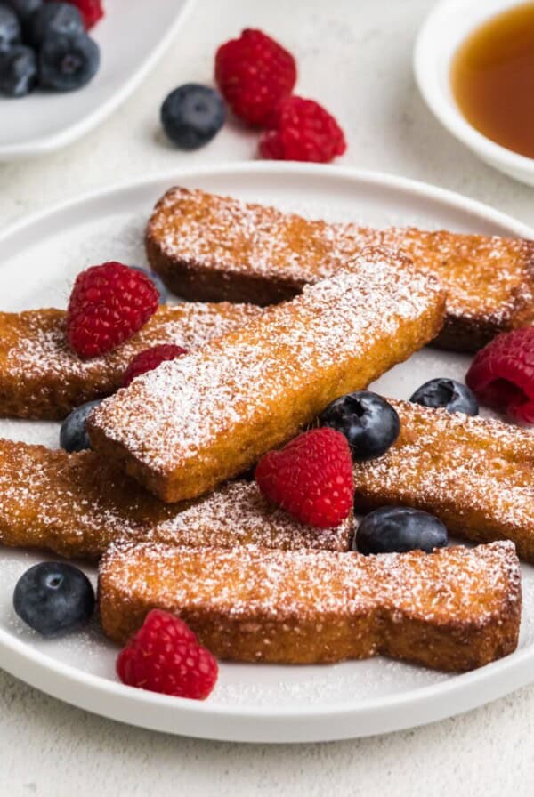 Air fried frozen french toast sticks fully cooked and topped with berries and powdered sugar. Ready to eat.