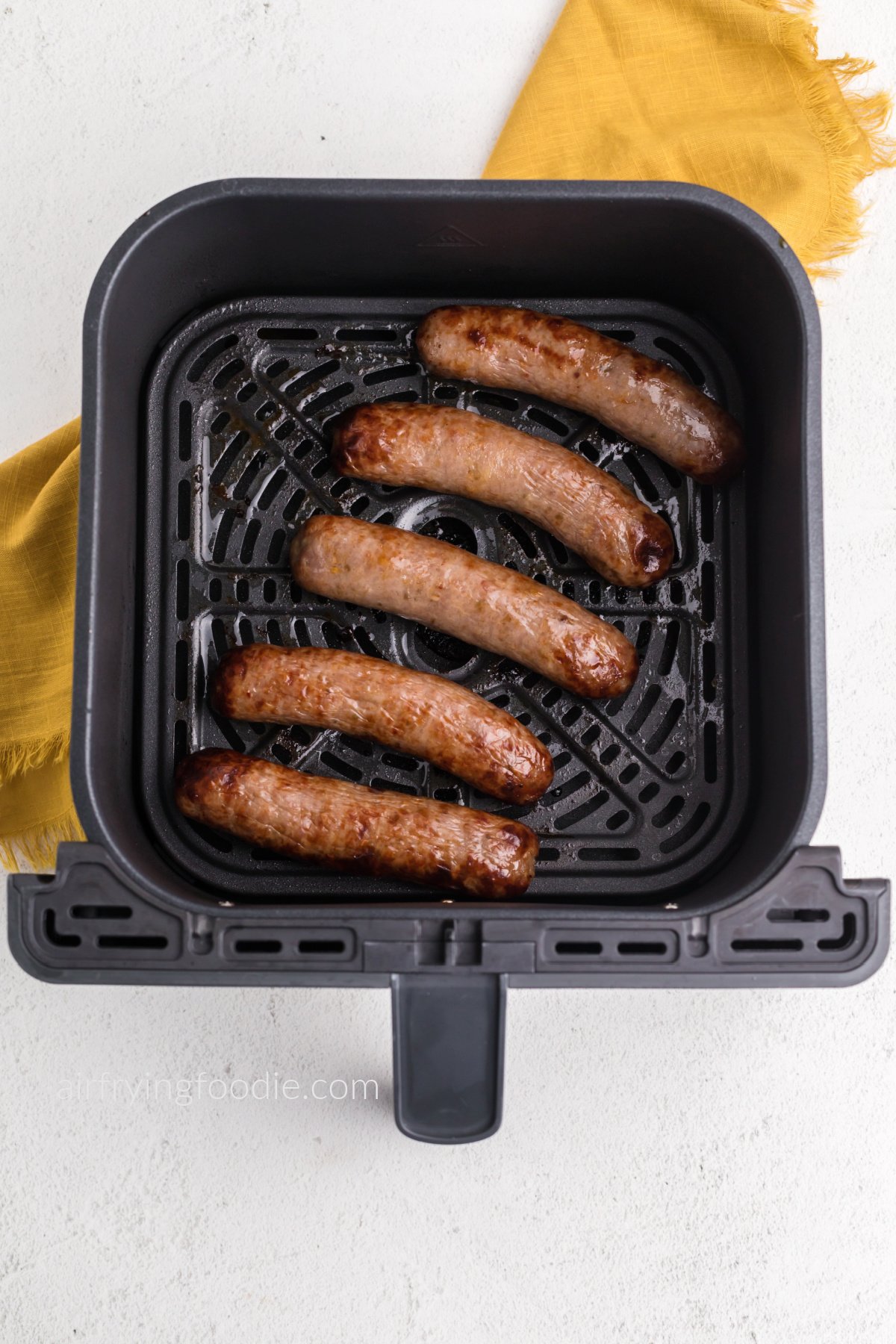 Italian sausage in basket of the air fryer, fully cooked and ready to serve.