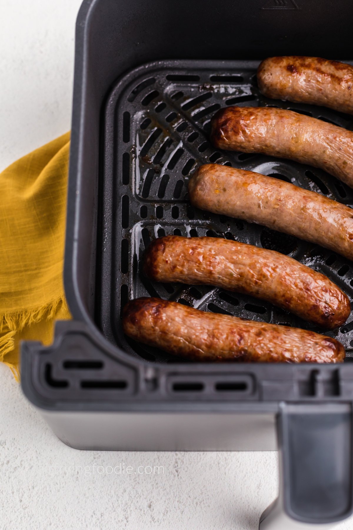 Close up photo of Italian sausage in the air fryer basket, ready to serve. 