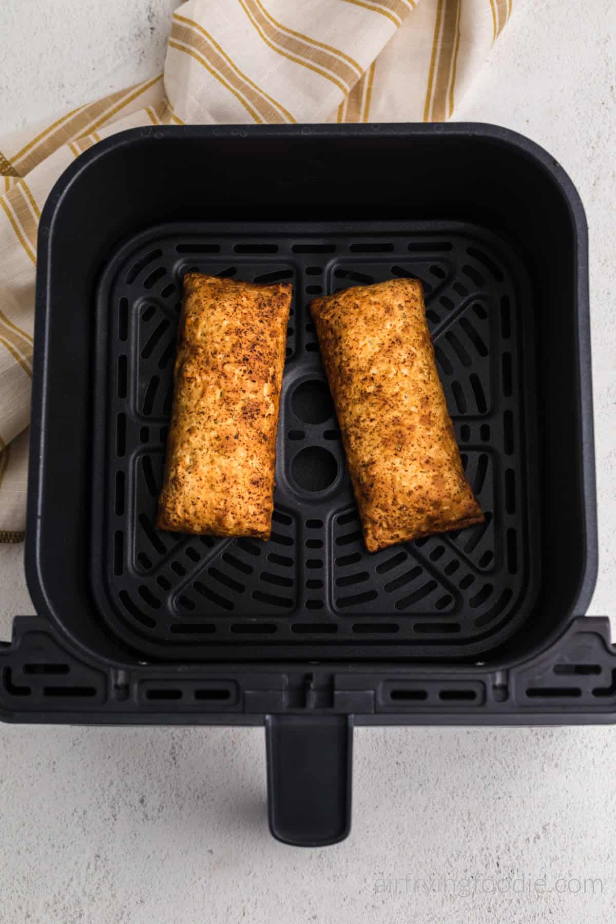 Golden brown hot pockets in air fryer basket, fully cooked and ready to serve.