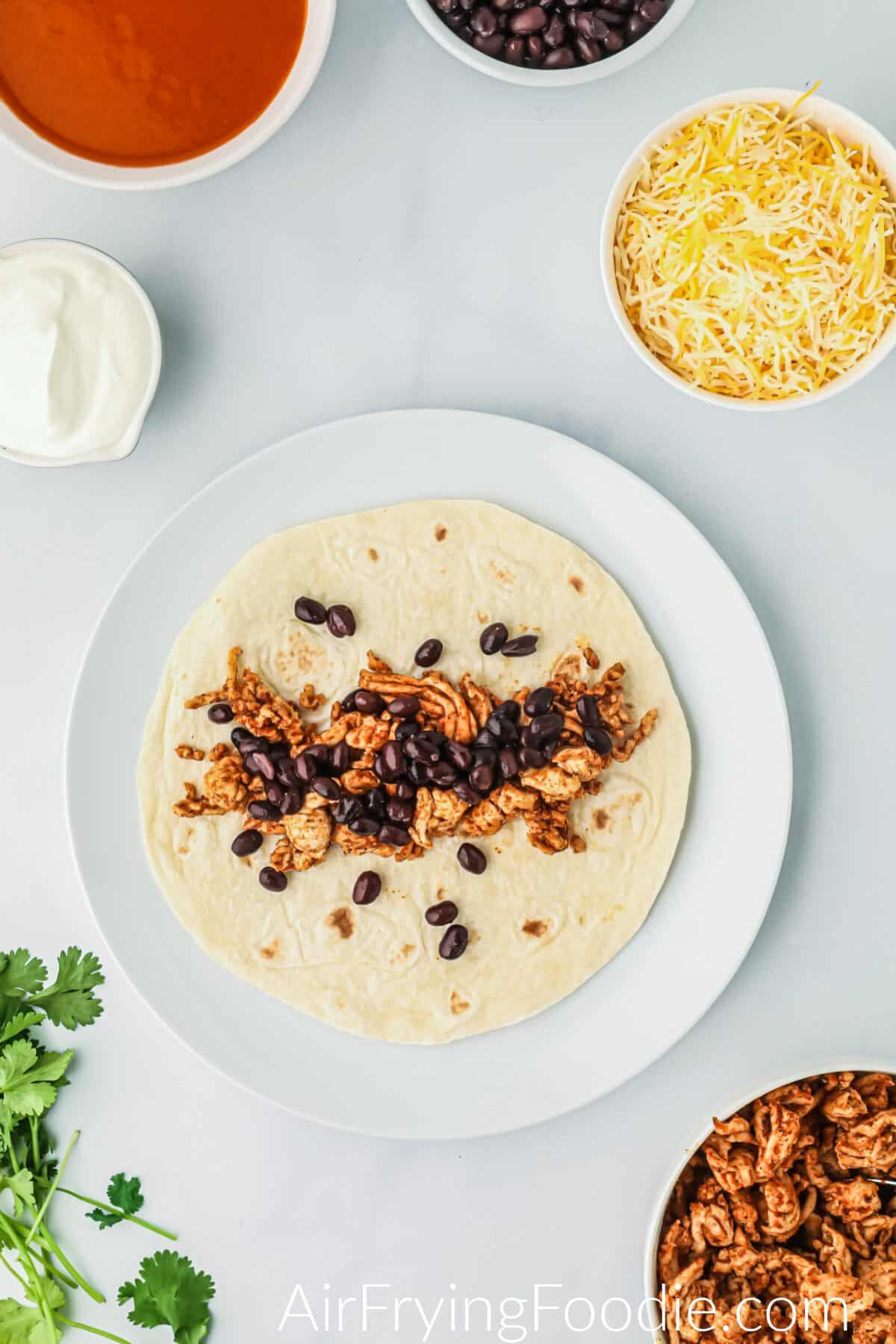 Ground chicken and beans scooped into the tortilla. 