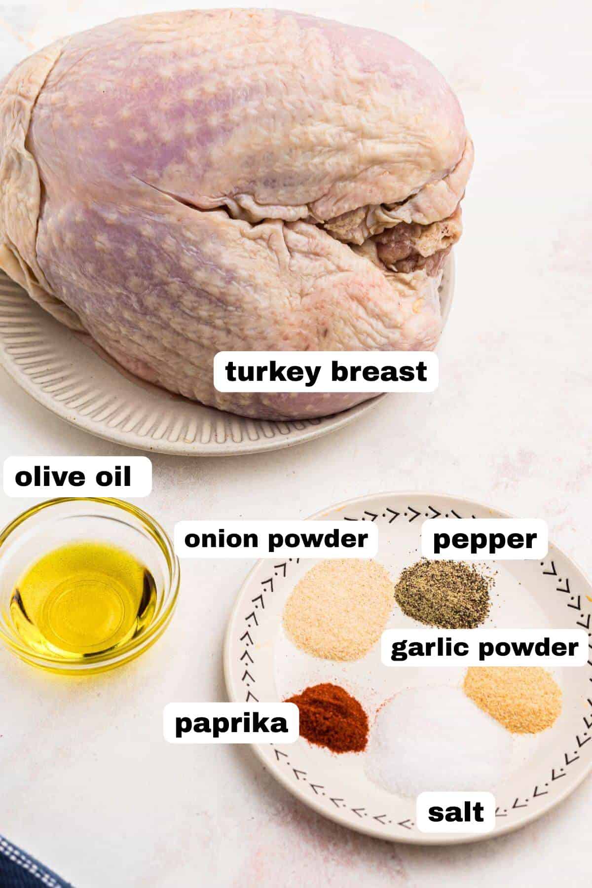 Uncooked turkey breast, olive oil, and seasonings, on a marble table. 
