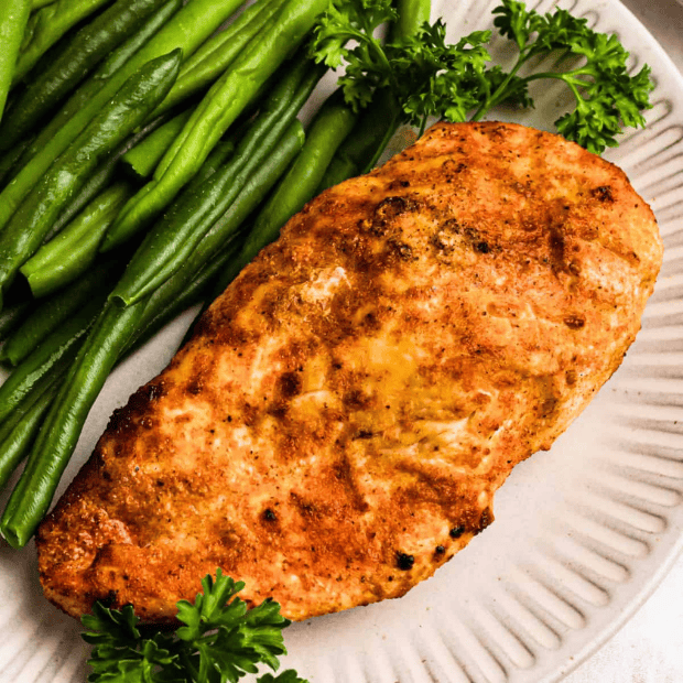 chicken breast and green beans on a plate ready to eat.