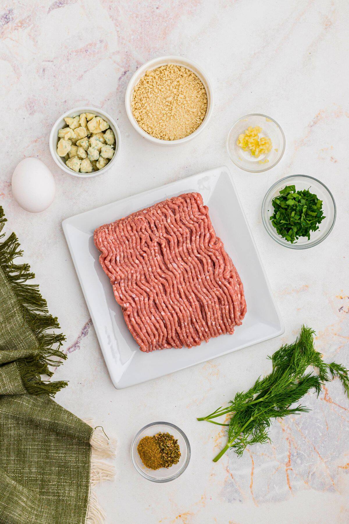 Ingredients needed to make Greek meatballs measured in small containers. 