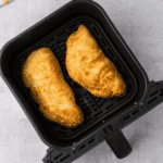 Overhead shot of calzones in the air fryr basket.