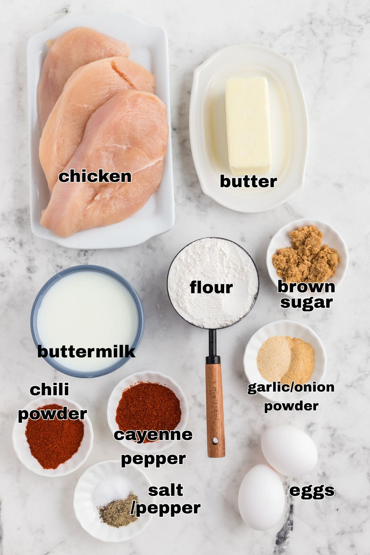 Ingredients needed to make Nashville Hot Chicken measured in small bowls on a marble table. 