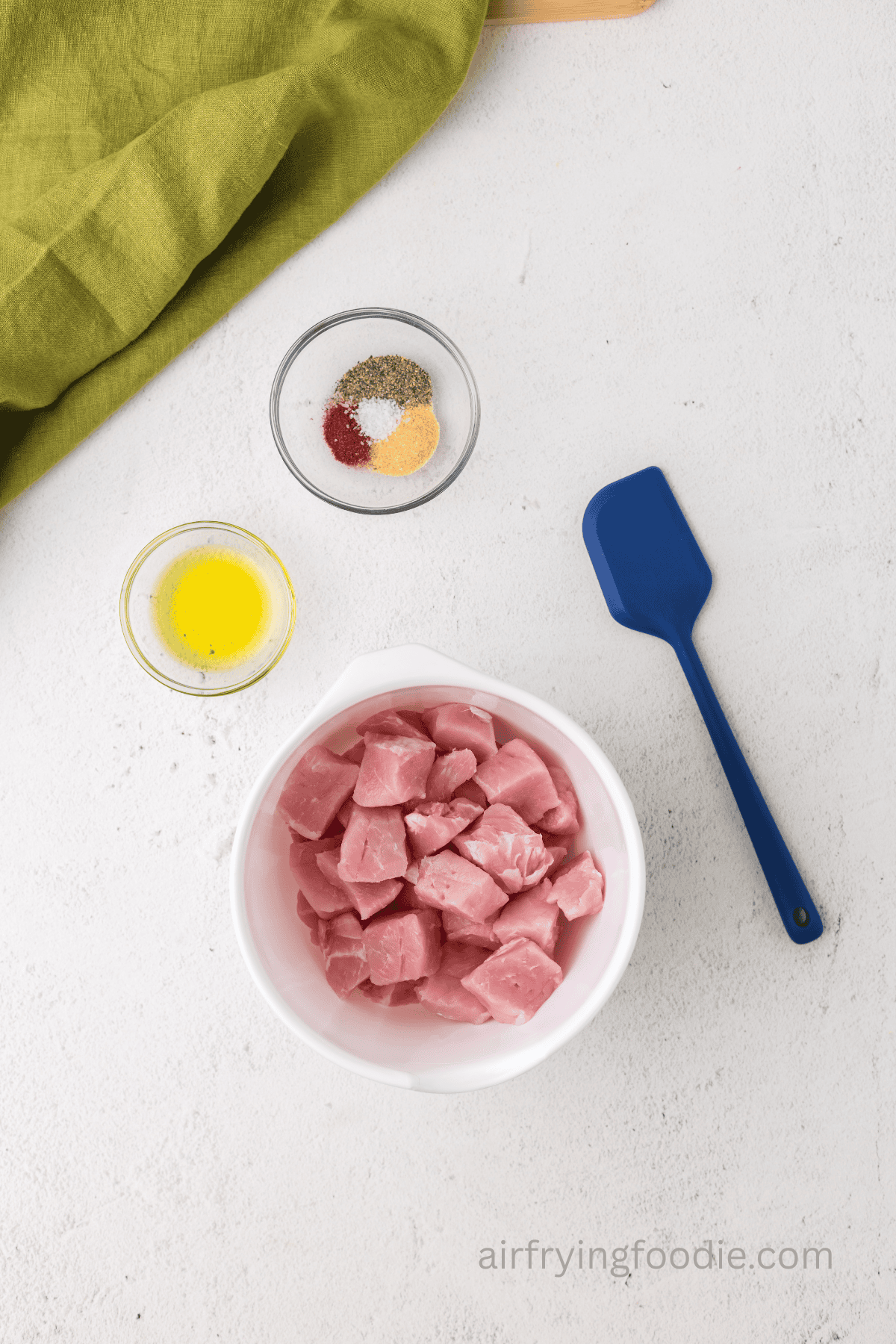 Pork chops cut into bites sized pieces in a medium mixing bowl.