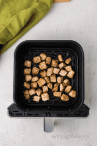 cooked pork chop bites in basket of the air fryer.