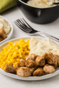 Plate of pork chop bites with corn and mashed potatoes.