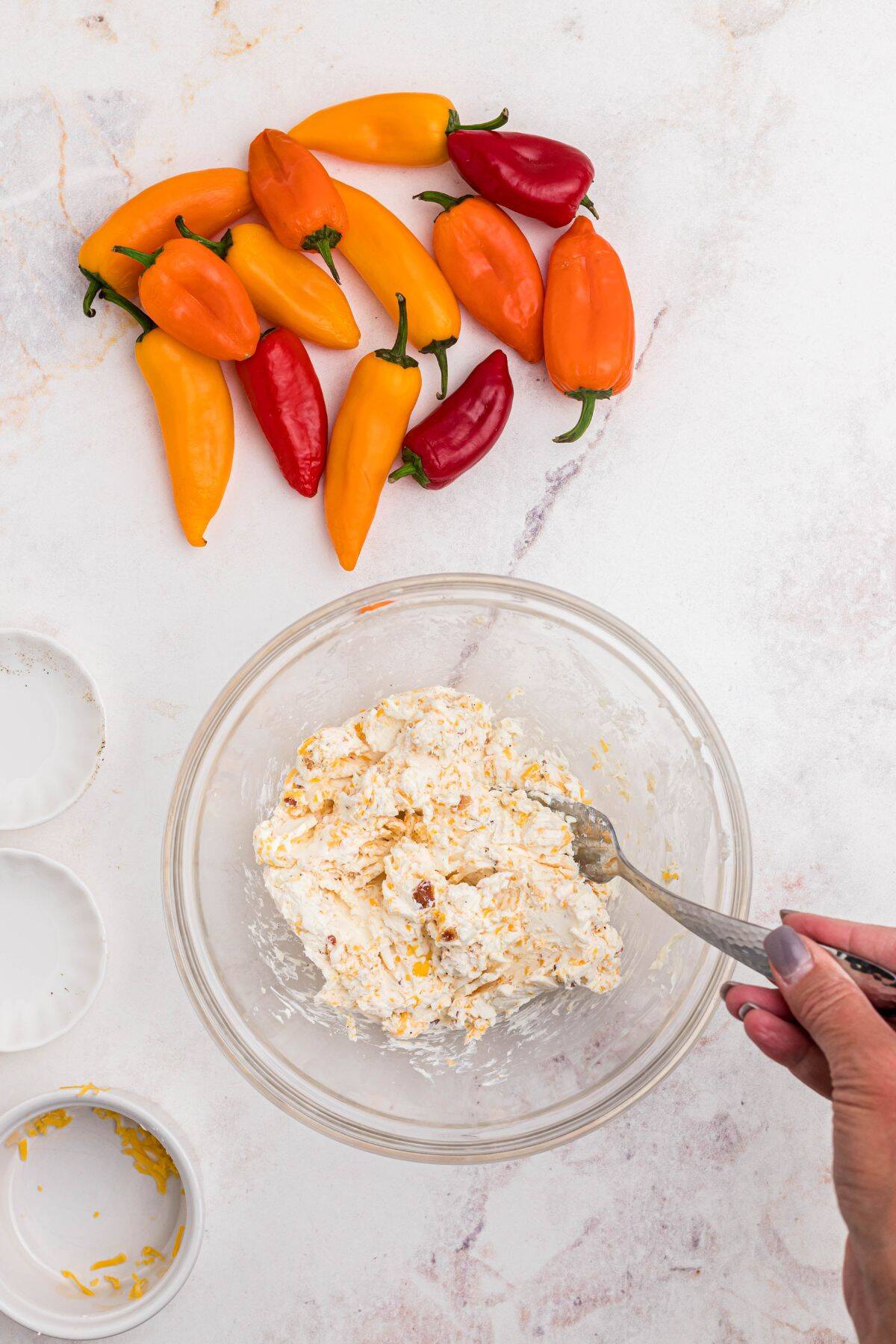 Cream cheese and other seasonings being mixed in a large bowl.