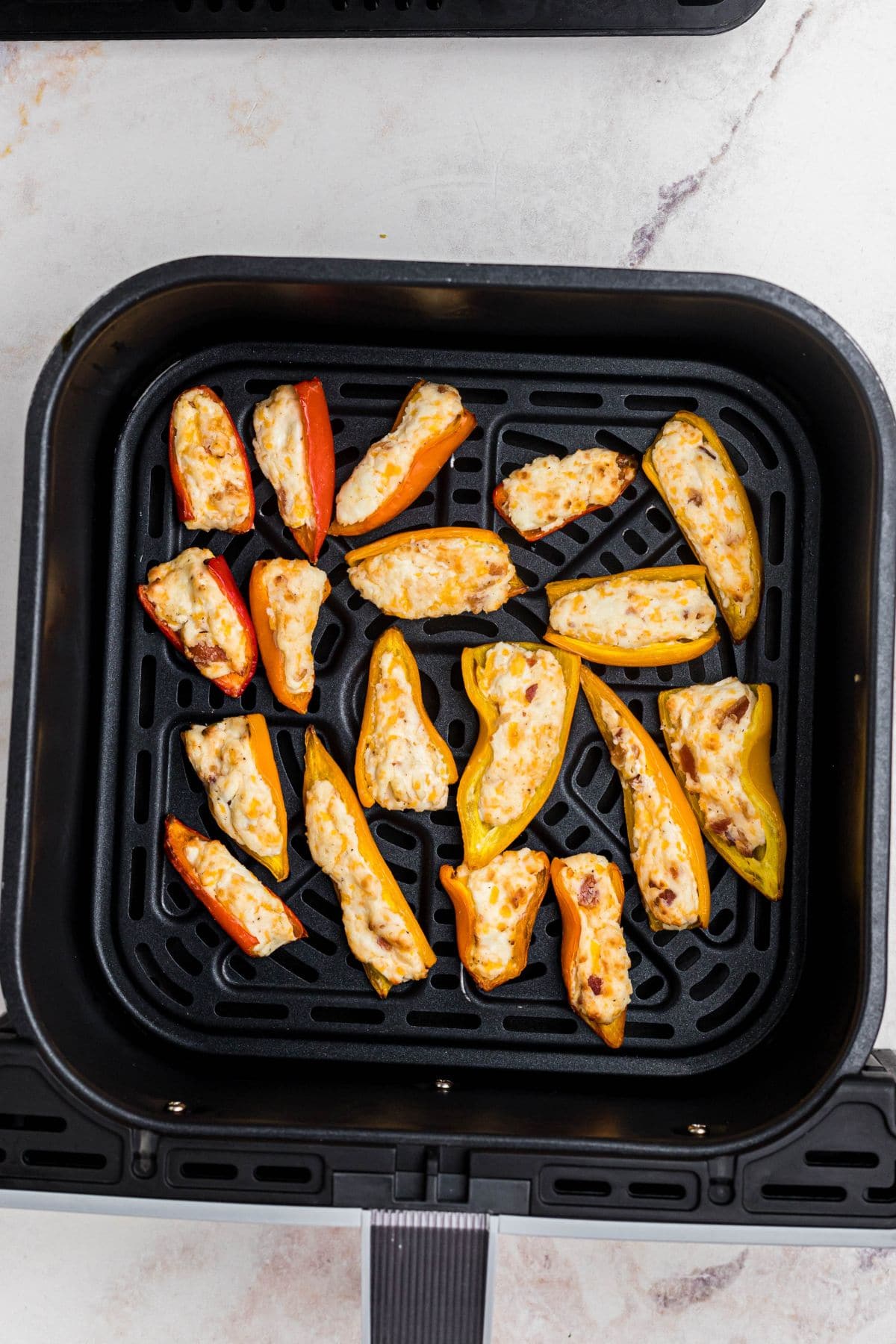 Mini stuffed peppers in the air fryer basket, after being cooked. 