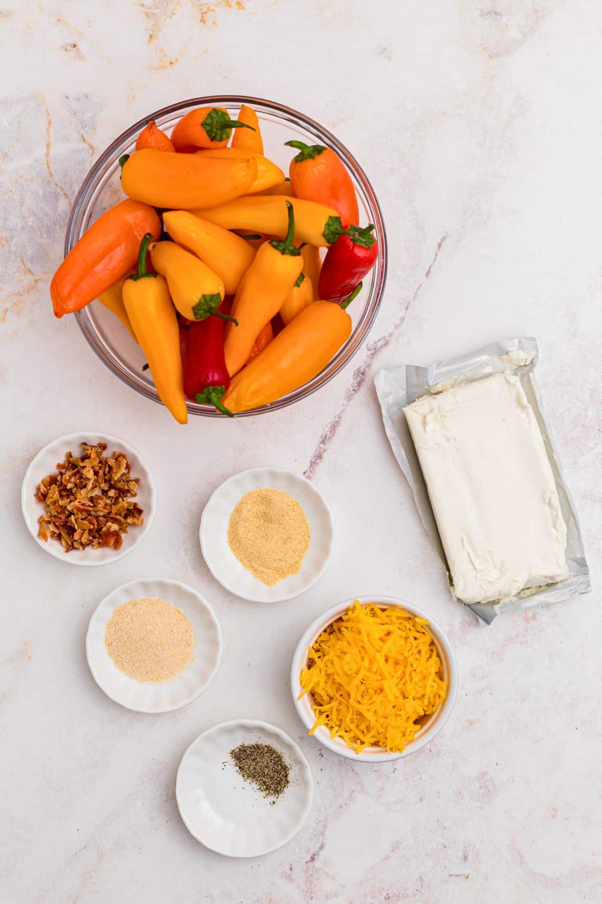 Ingredients measured into small bowls on a white marble table. 
