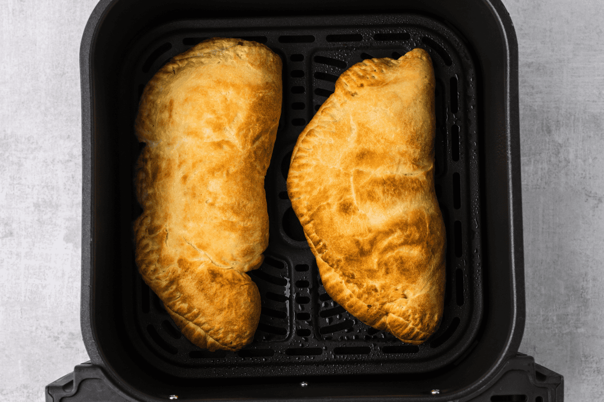 Calzones in the air fryer basket, fully cooked. 
