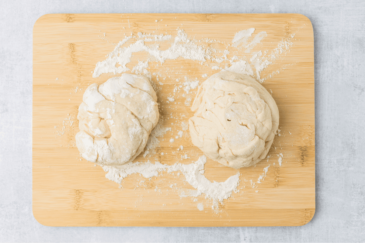 dough divided into two on a cutting board. 