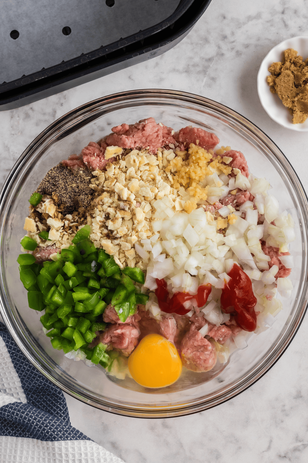 Large mixing bowl with ingredients to make turkey meatloaf.