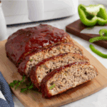 Sliced turkey meatloaf on a cutting board.