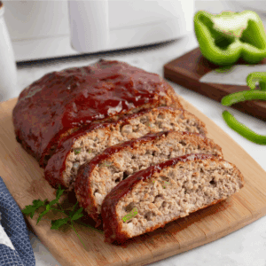 Sliced turkey meatloaf on a cutting board.