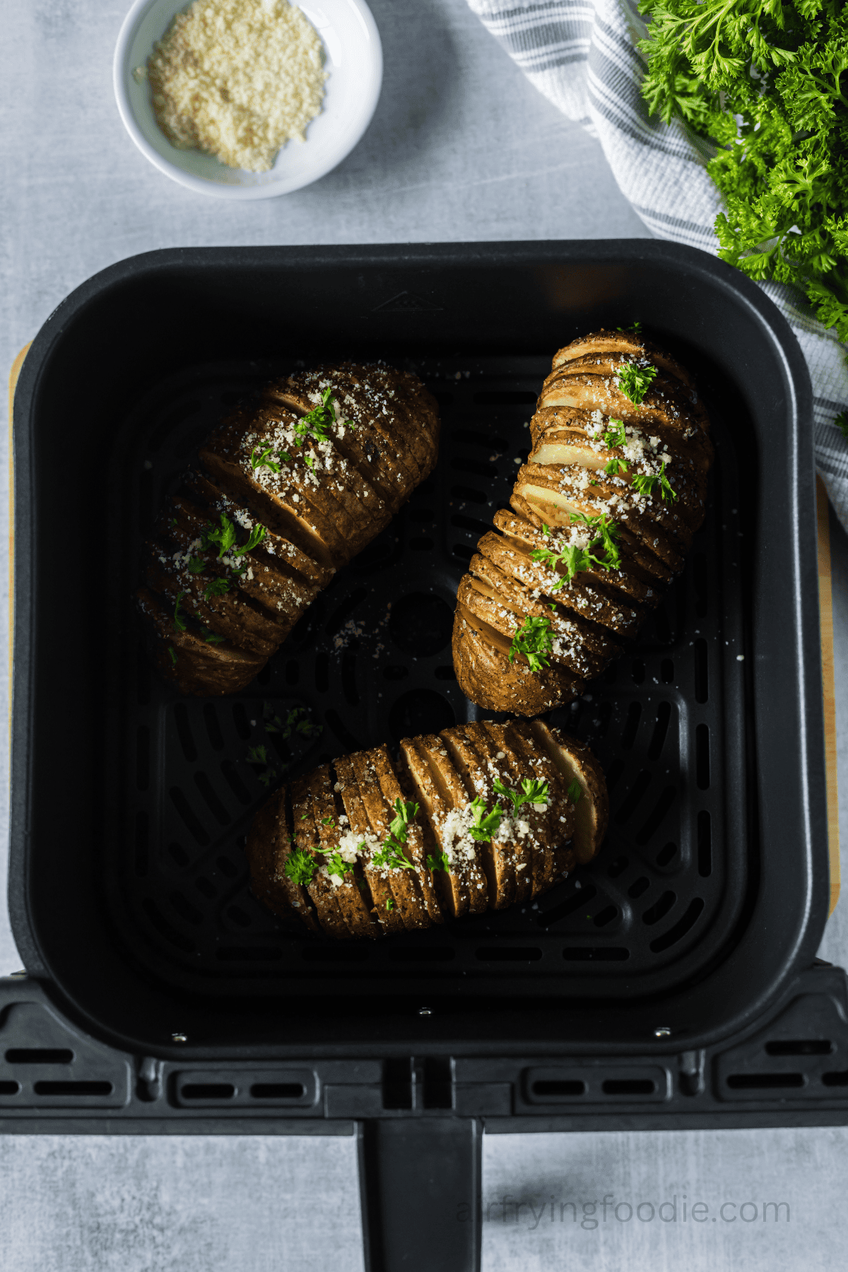 Air fried Hasselback potatoes in the air fryer basket.