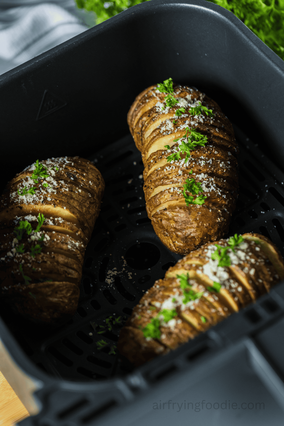Air fried Hasselback potatoes in the air fryer basket.