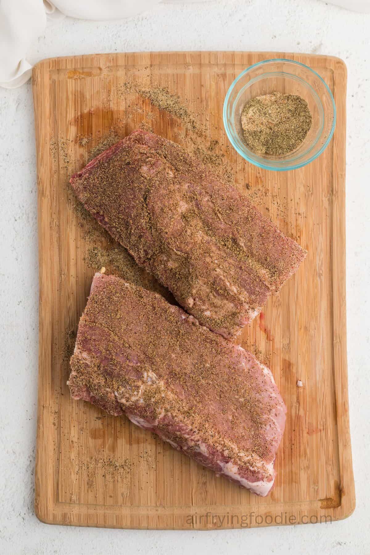Seasoned ribs on a cutting board.