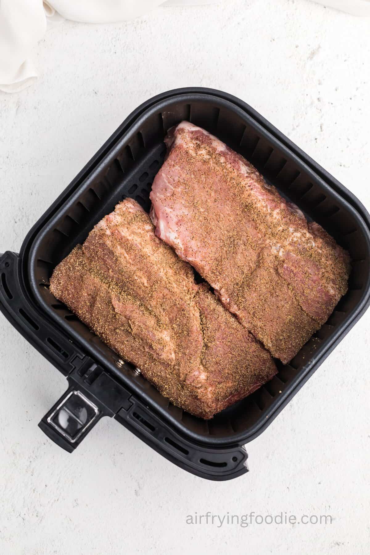 Ribs in the air fryer basket ready to cook.