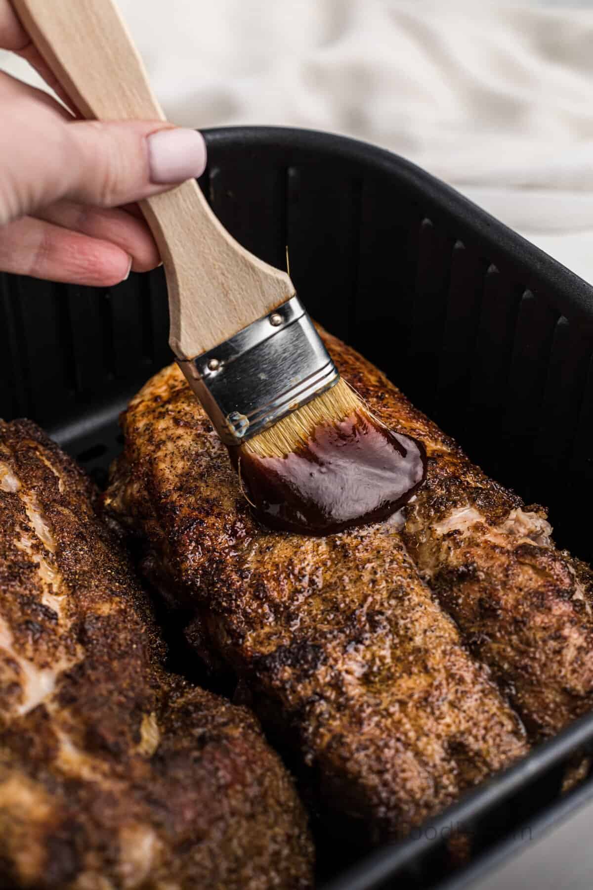 Brushing the BBQ sauce on the ribs.