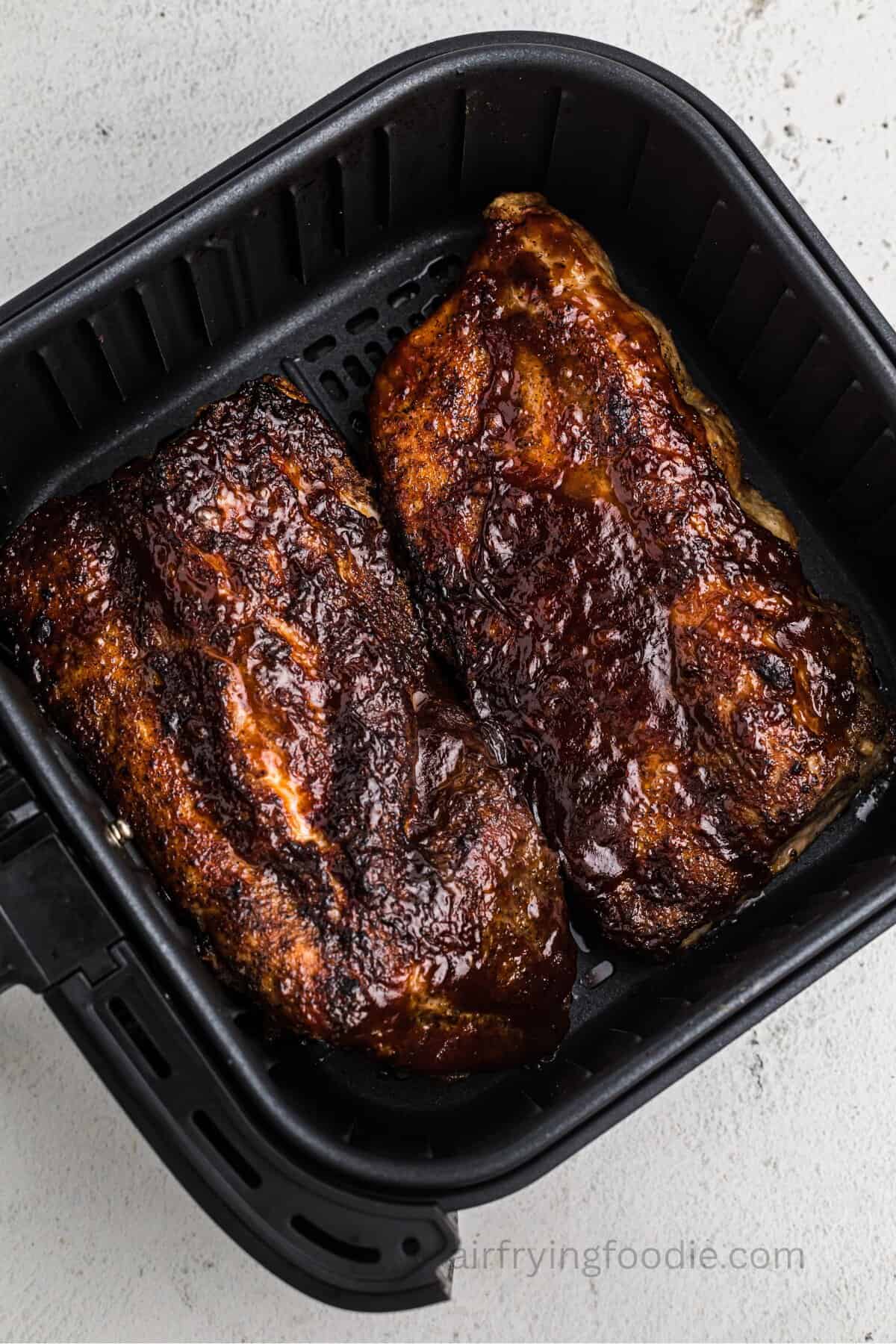 Cooked air fryer BBQ ribs in the air fryer basket.