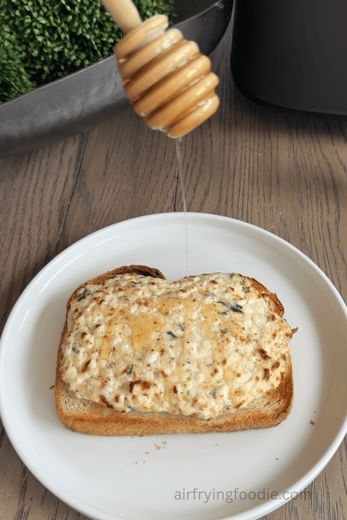 Hot honey being drizzled over garlic herb cottage cheese toast.