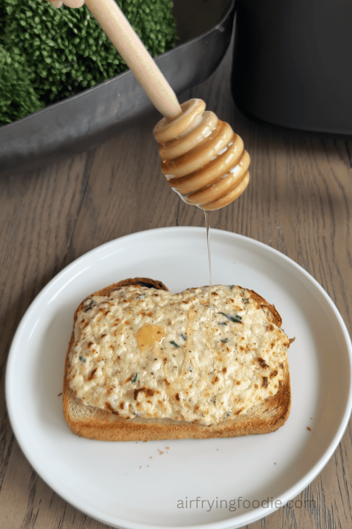 Air fried garlic herb cottage cheese toast having hot honey drizzled on it.